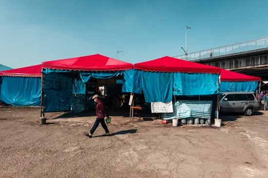 Fuhe Flea Market, le mec qui marche avec une veste en cuir et une casquette gavroche, les mains dans le dos portant un sac / Taïwan (2024)
