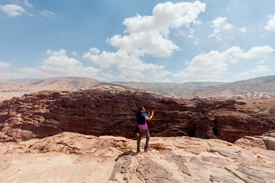 Touriste au t-shirt rose et pull sur les épaules en train de prendre des photos / Jordanie (2019)