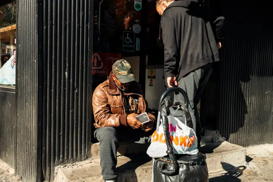 Sur les marches à l'entrée d'un magasin / New York, USA (2022)