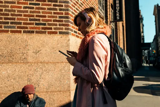 La femme en rose qui regarde son smartphone et le SDF qui la regarde / New York, USA (2022)
