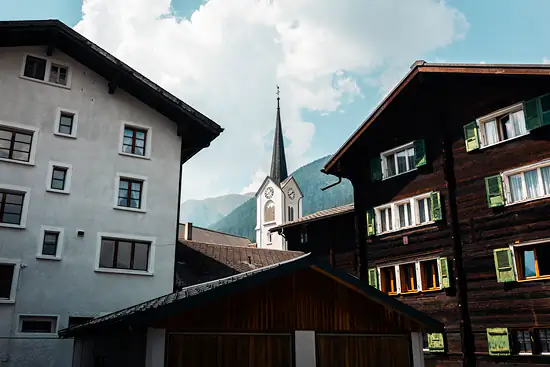 Dans les ruelles d'Ulrichen, vue sur l'église St. Nikolaus / Suisse - Été (2026)